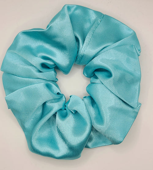 Turquoise satin scrunchie on a light gray background