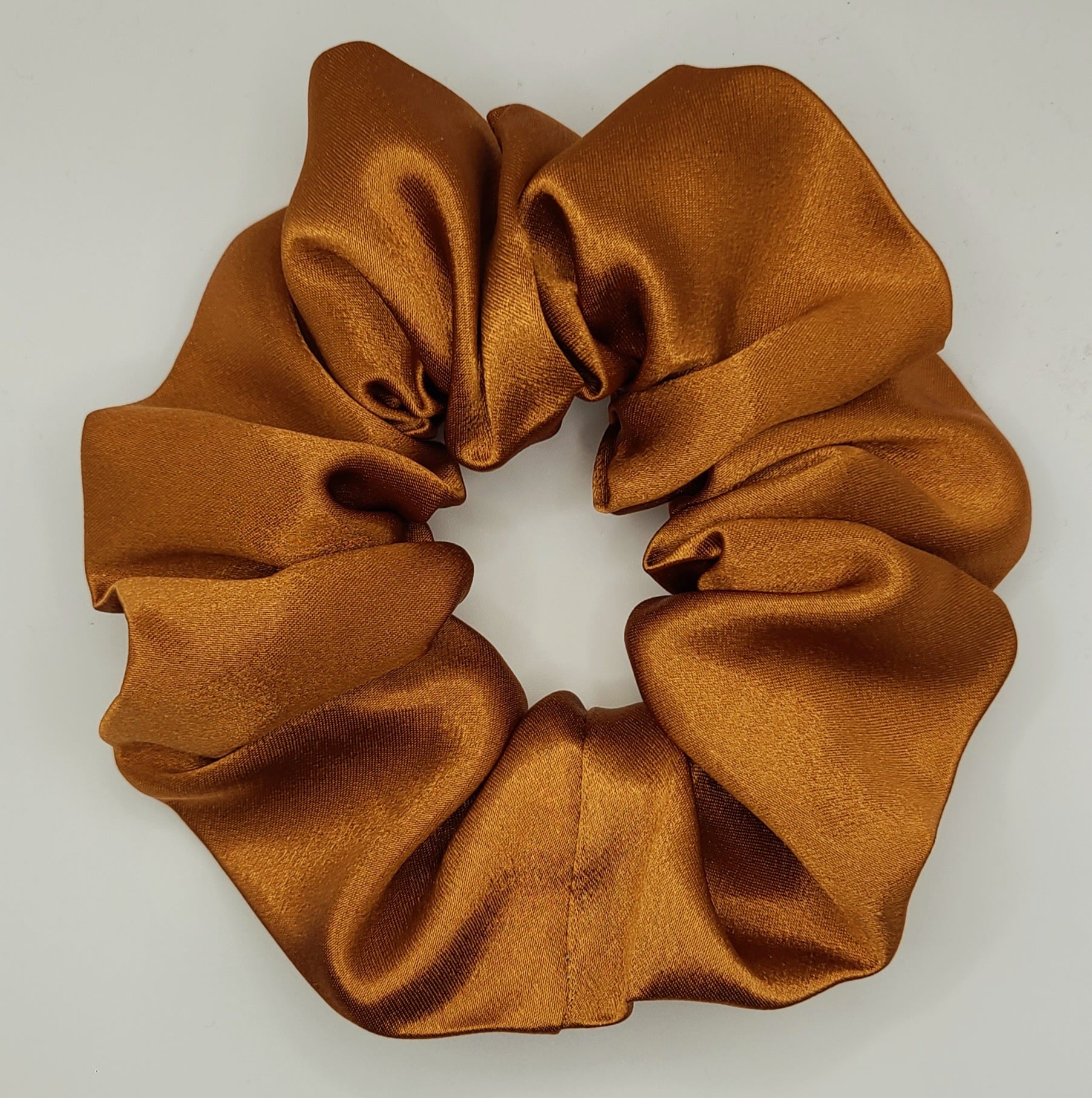 Golden Brown satin scrunchie on a light gray background