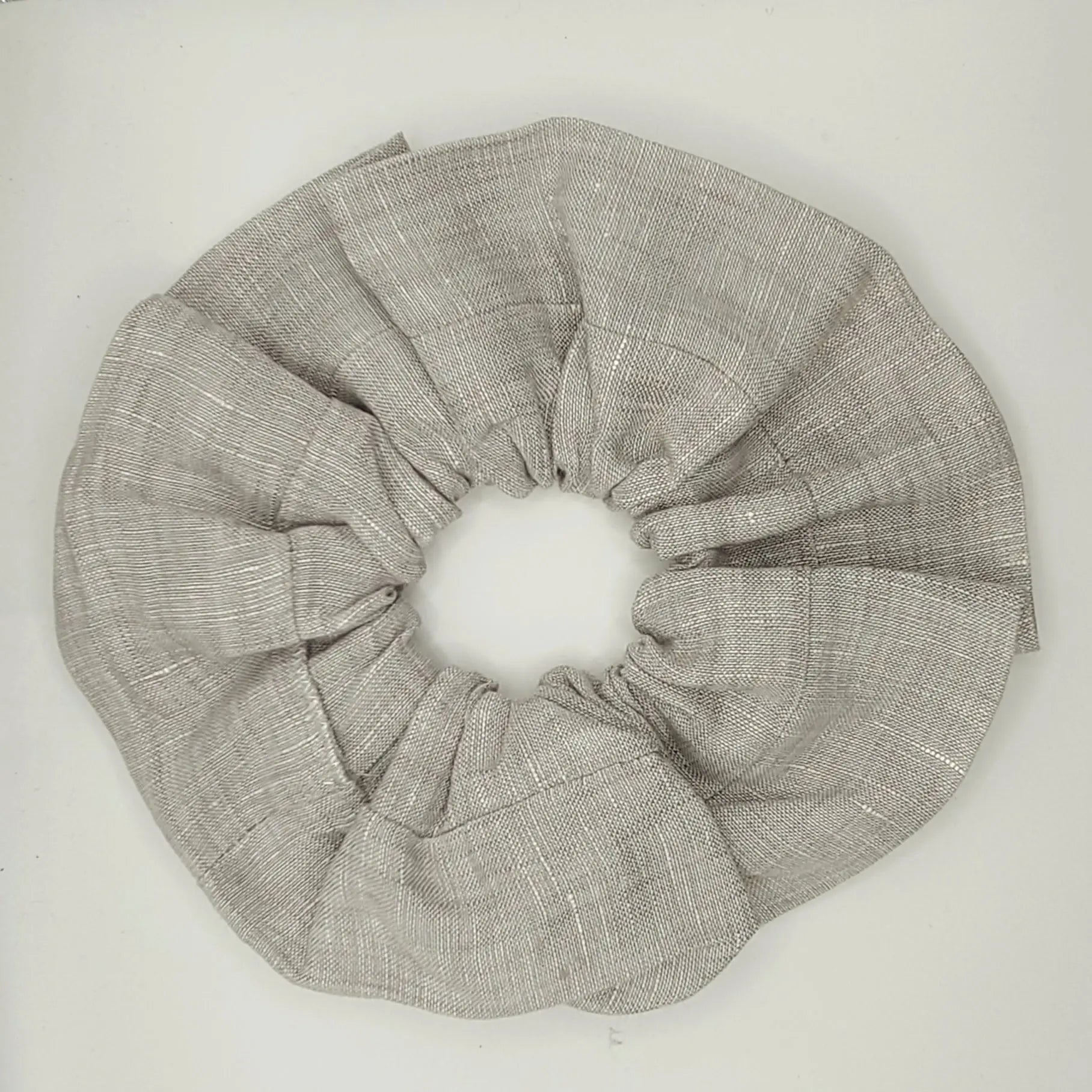 Beige fabric scrunchie on a white background