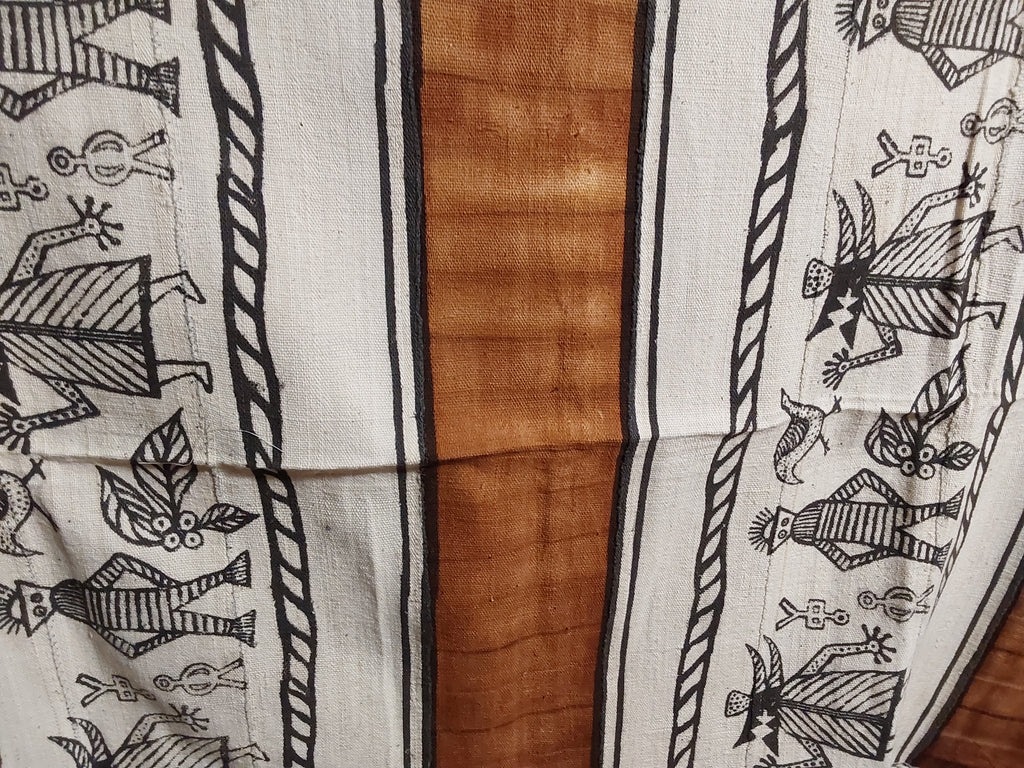 Textile with black patterns on white fabric over a wooden surface