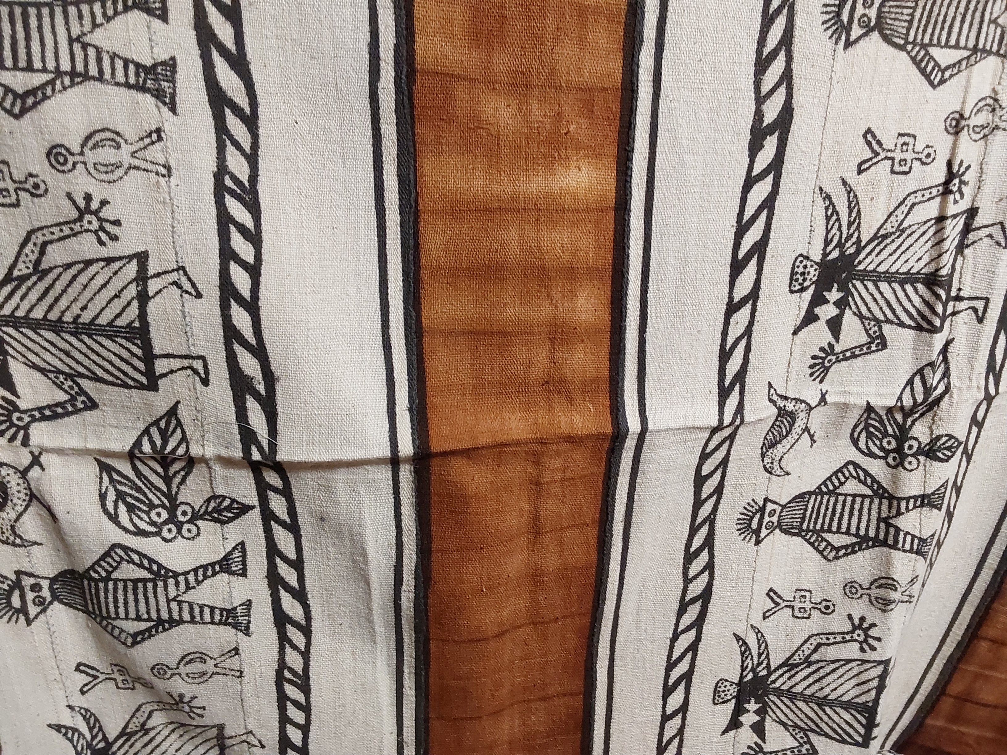 Textile with black patterns on white fabric over a wooden surface