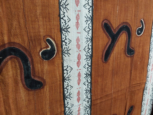 Close-up of a mudcloth surface with decorative carvings and patterns.