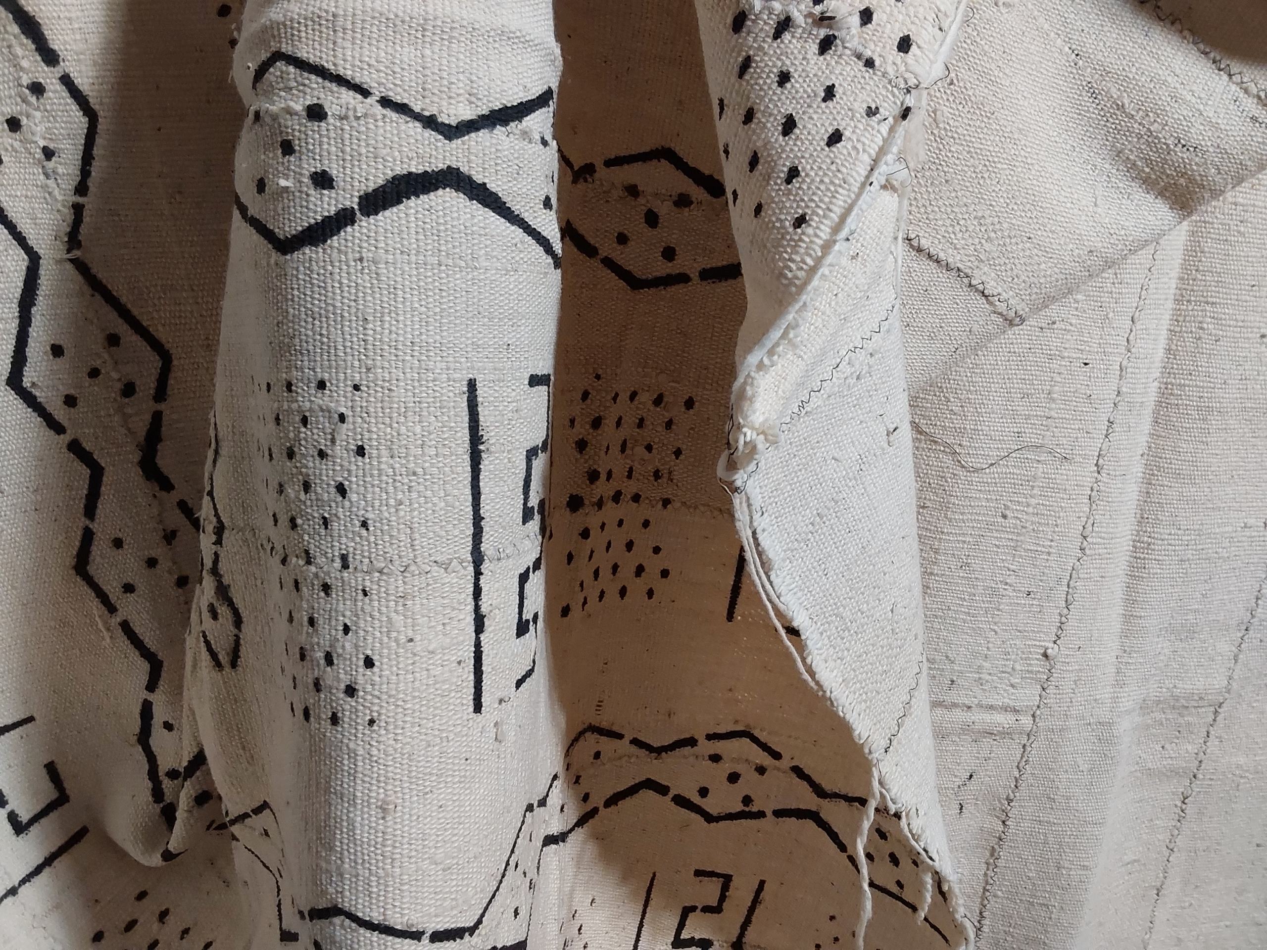 Close-up of textured fabric with geometric patterns in black on a beige background