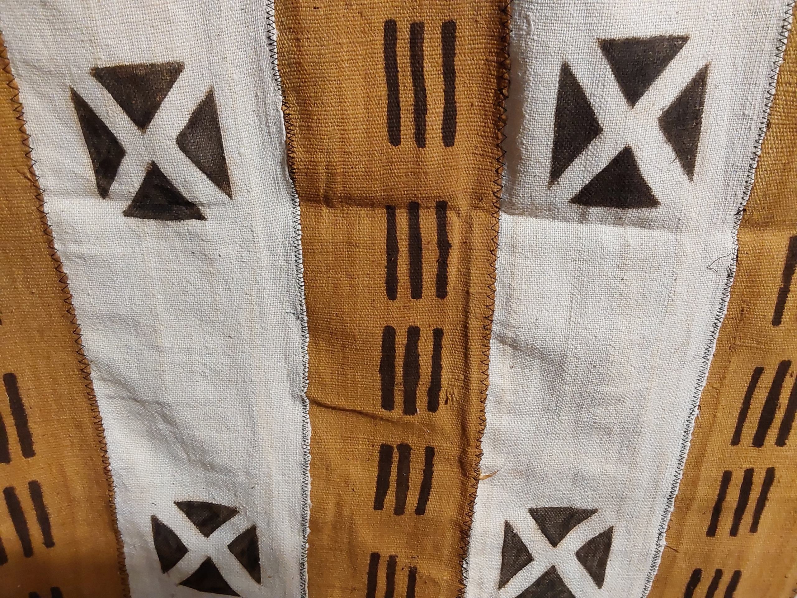 Textile with geometric patterns in brown, white, and black on a brown background