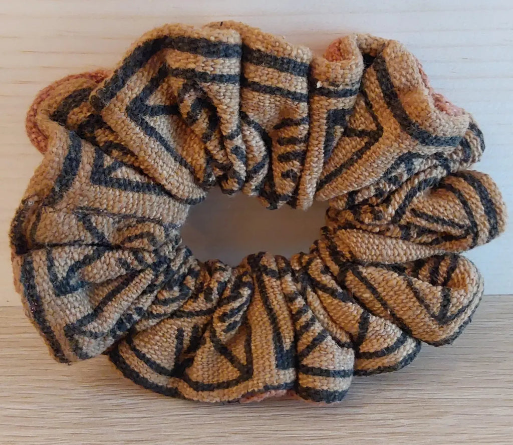 Textured scrunchie with tribal pattern on a wooden surface