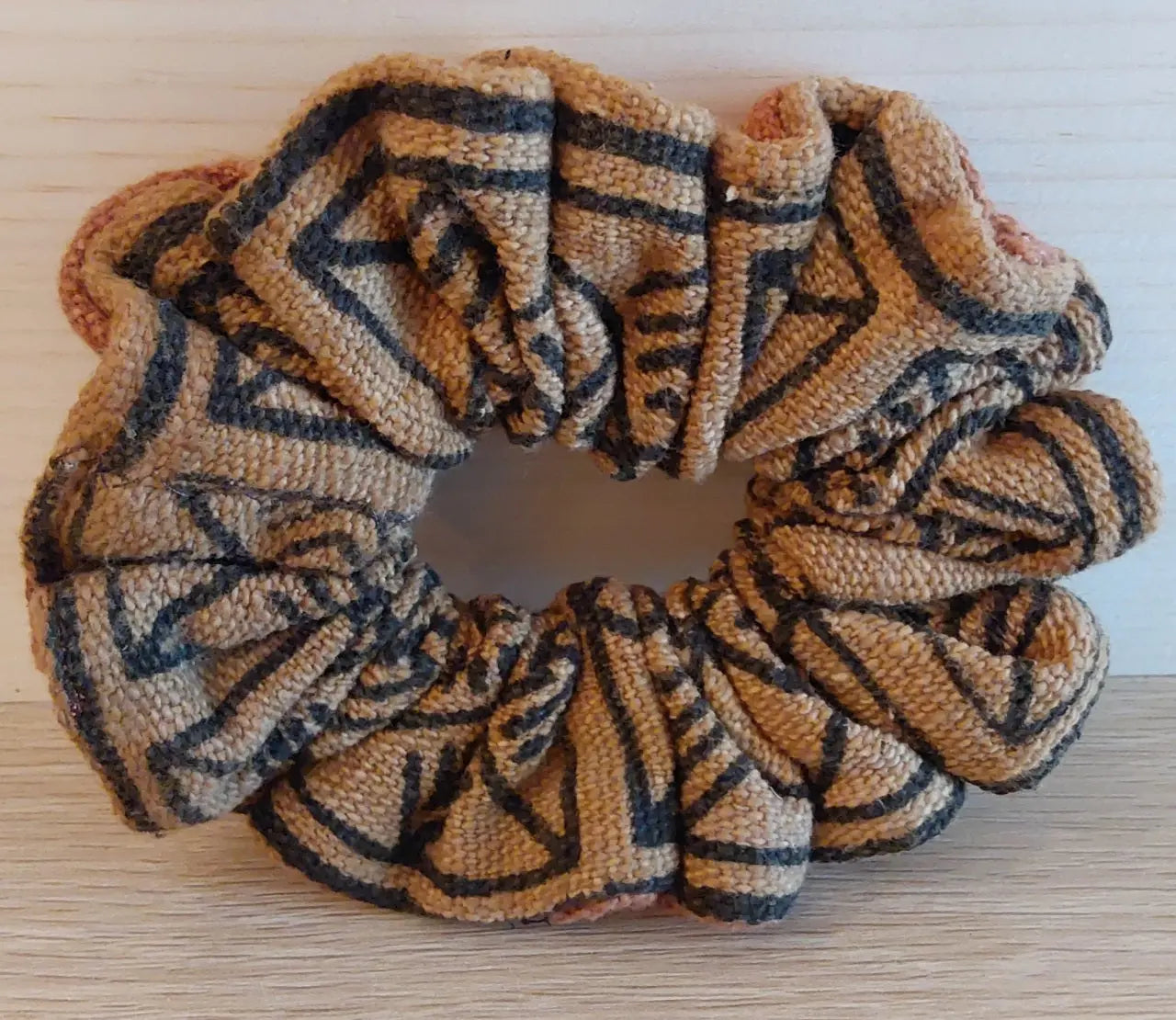Textured scrunchie with tribal pattern on a wooden surface