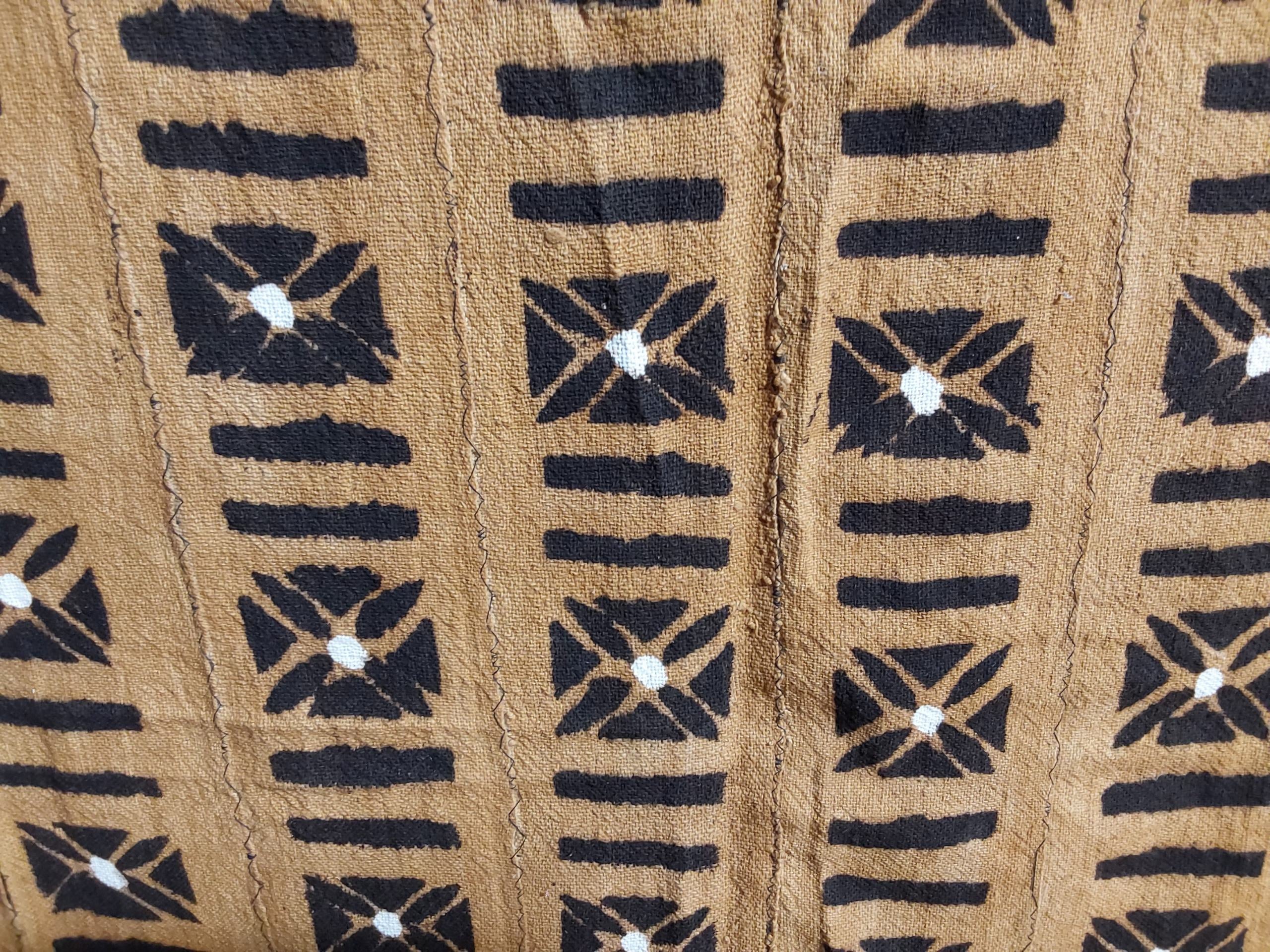 Close-up of a textured fabric with black geometric patterns on a brown background