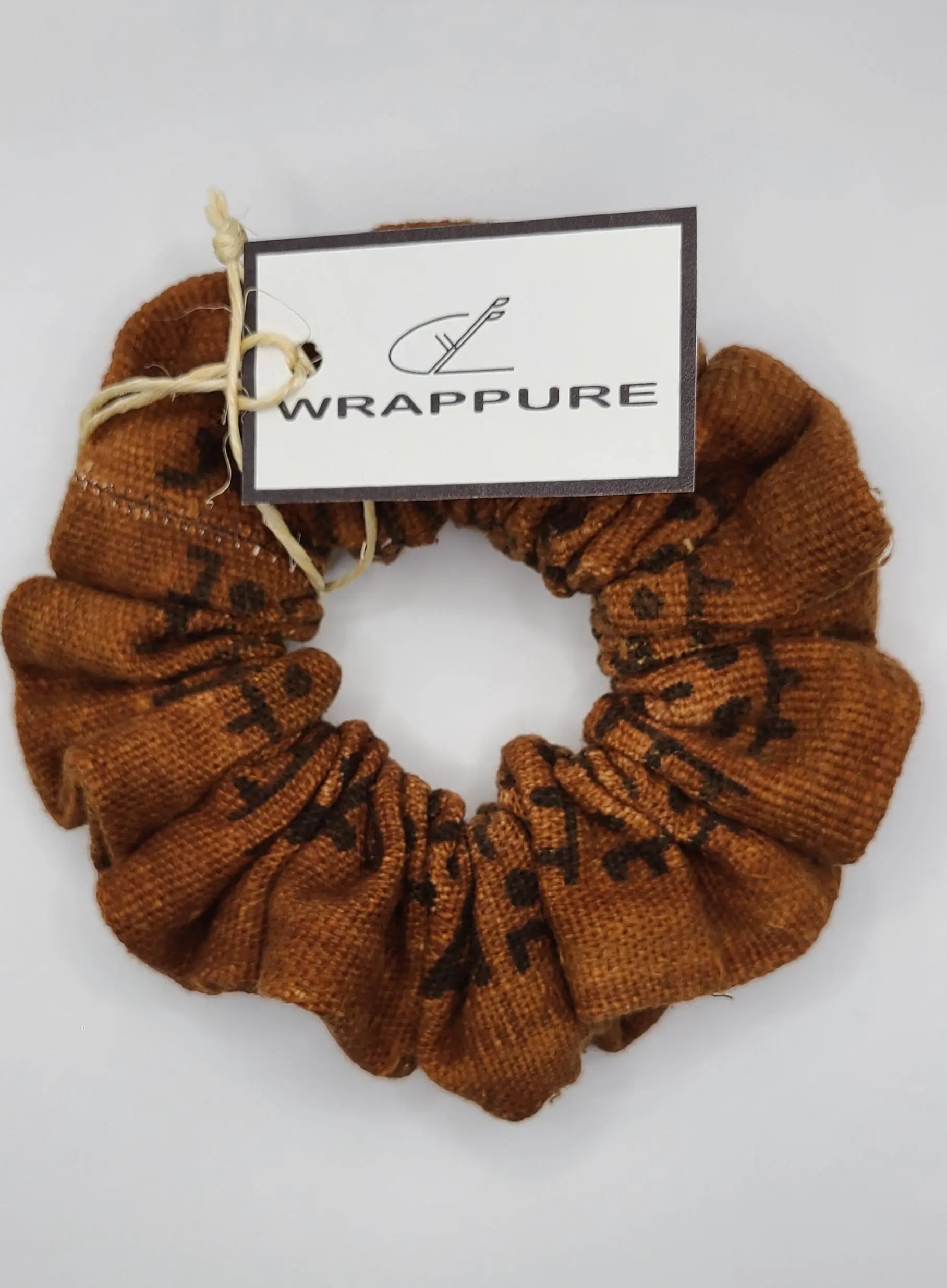 Brown scrunchie with a 'Wrappure' tag on a light gray background