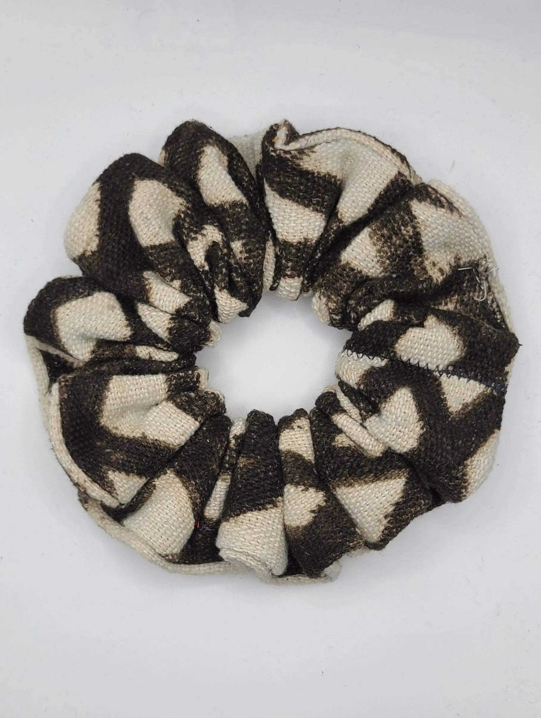 Black and beige patterned scrunchie on a white background