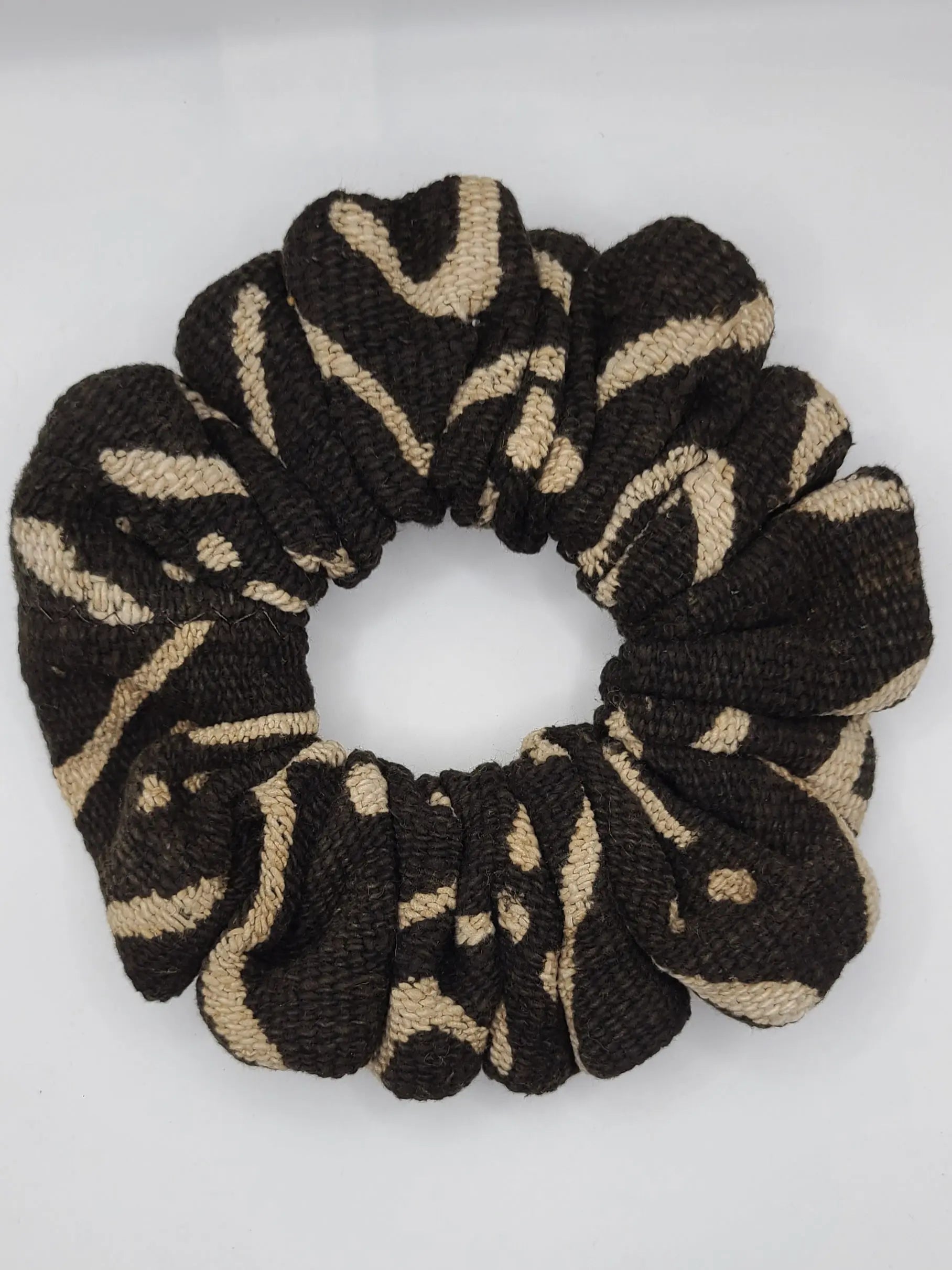 Black and beige patterned scrunchie on a white background