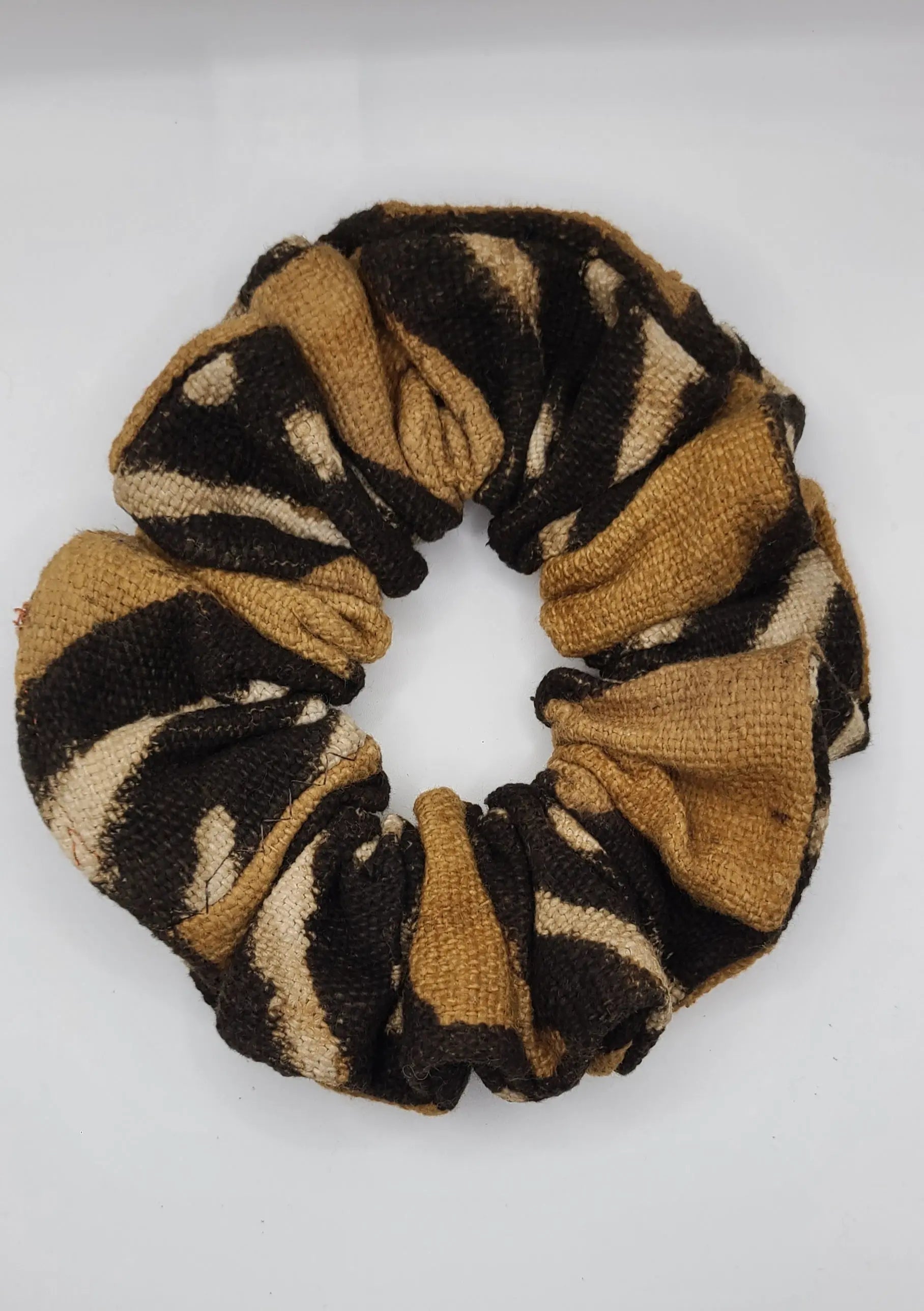 Brown, black and beige patterned scrunchie on a white background
