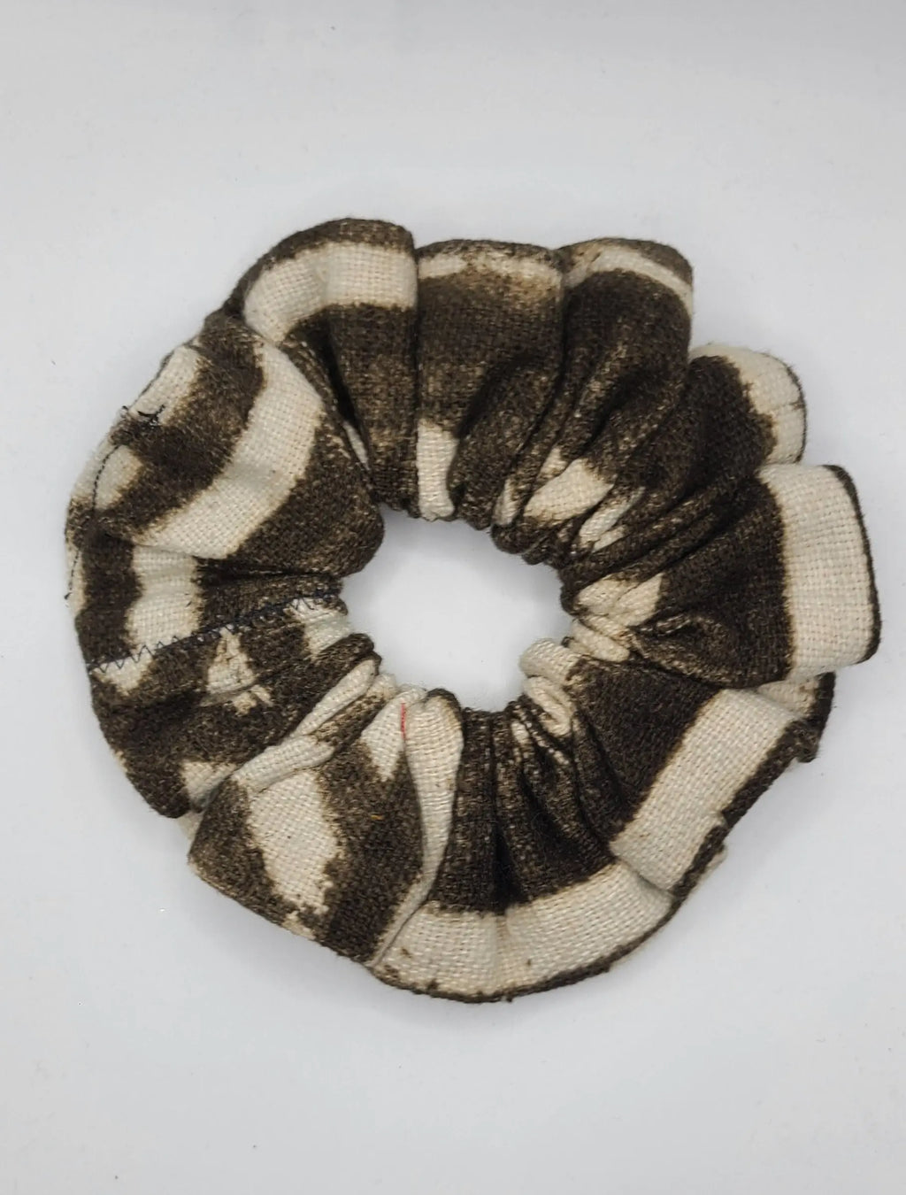Black and beige patterned scrunchie on a white background