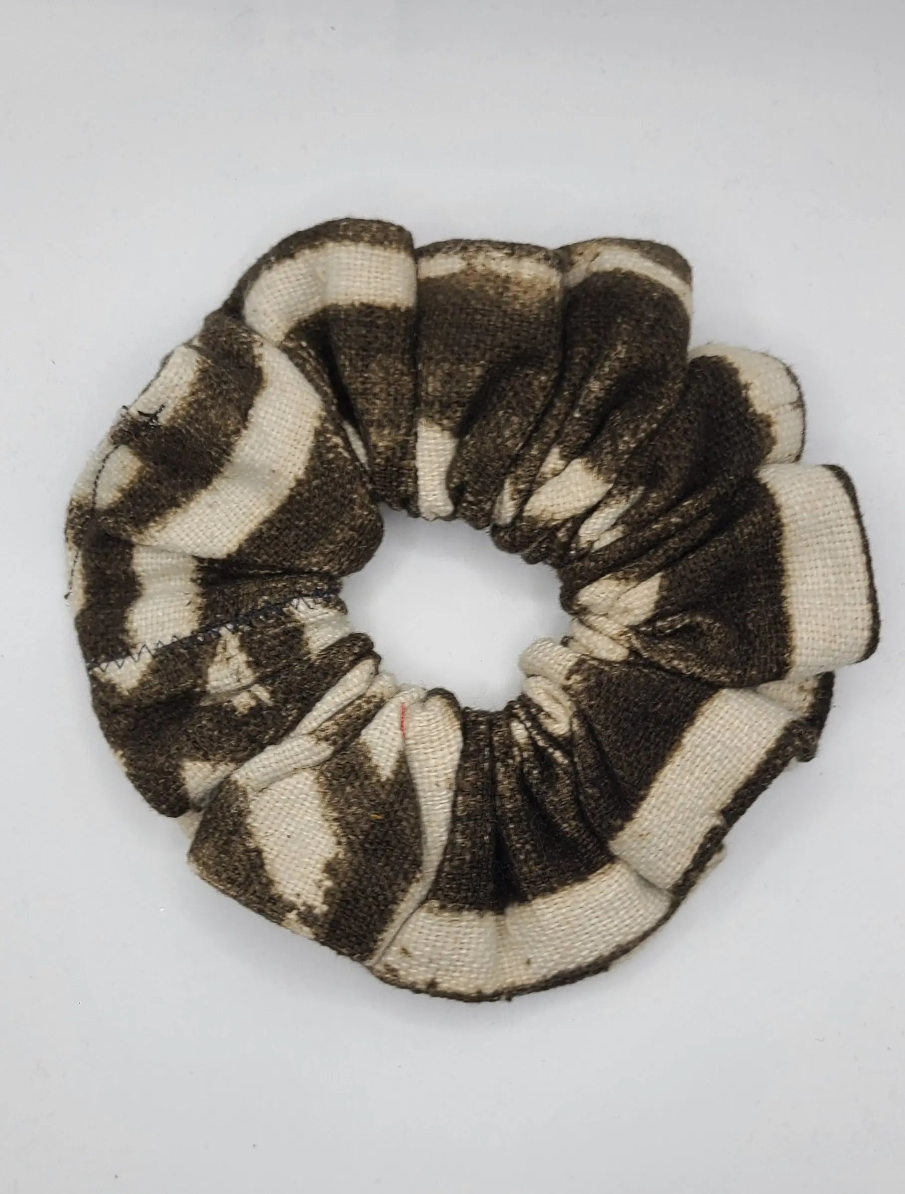 Black and beige patterned scrunchie on a white background