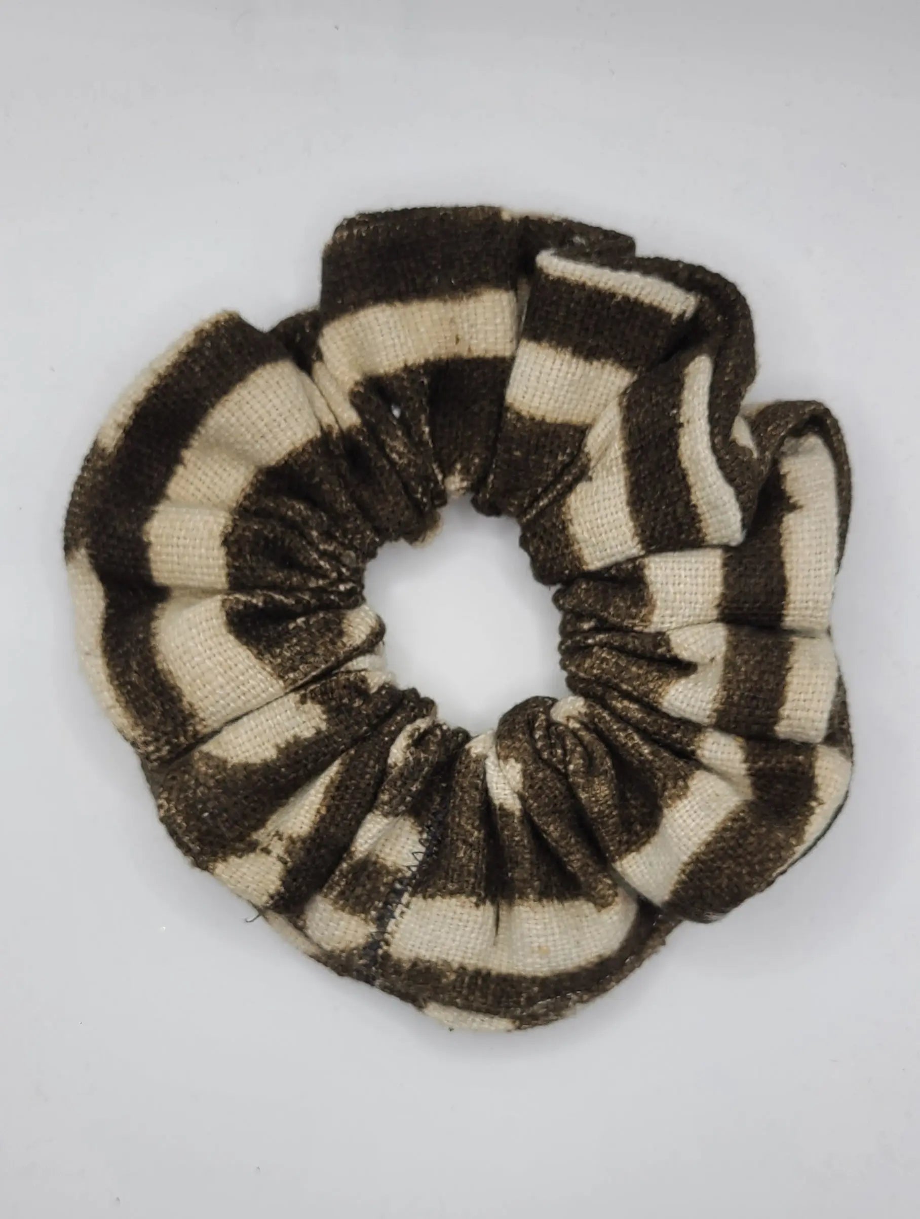Black and beige striped scrunchie on a white background